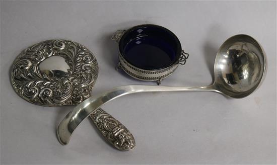 A repousse silver hand mirror, a pierced silver butter dish and liner and a plated soup ladle.